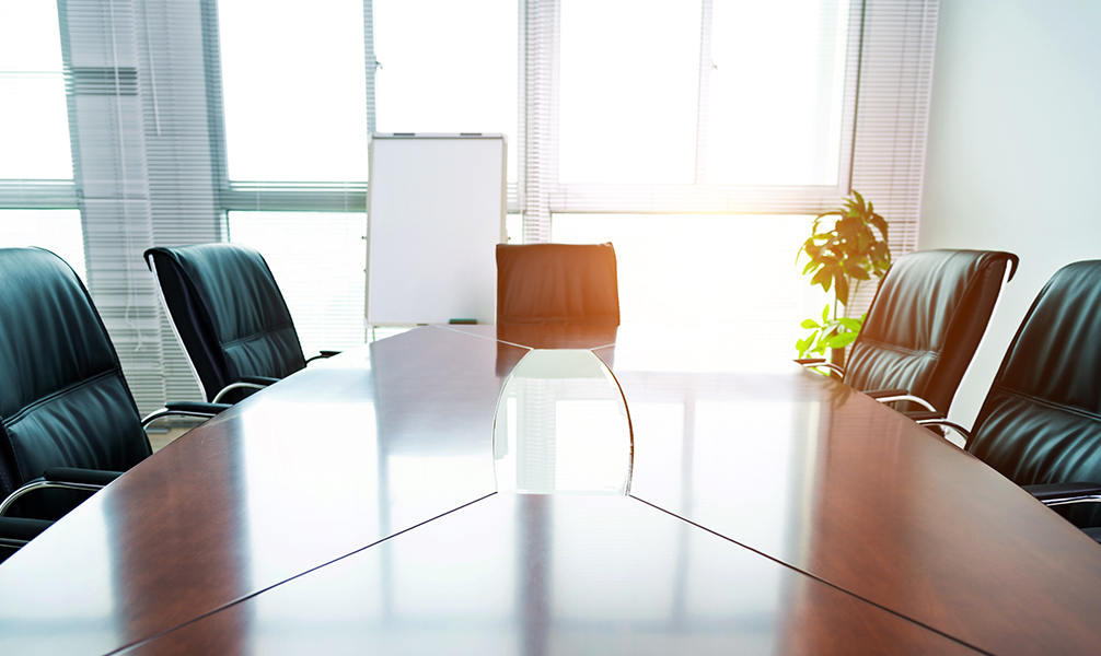 Photo of sun-filled, empty board room. 