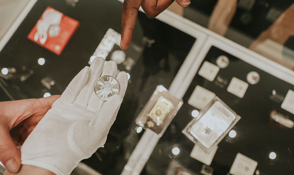 Close up of a silver coin in gloved hand. Close up of a silver coin in gloved hand.